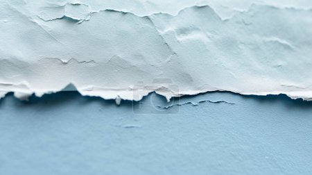 Close-up of peeling blue and white paint on a wall, creating a textured, layered effect.