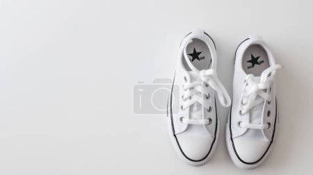 Une paire de baskets blanches propres avec des lacets, affichées sur un fond blanc, mettant l'accent sur la simplicité et le style minimaliste.