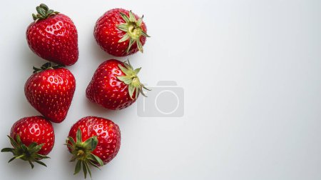 Five fresh strawberries arranged on a plain white background, highlighting their vibrant red color and green leaves