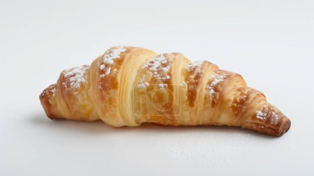 A single croissant dusted with powdered sugar, showcasing its flaky, golden layers on a white background.