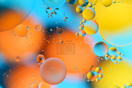 Foto de Manchas azules y anaranjadas con círculos multicolores similares a la galaxia y al microcosmos - Imagen libre de derechos
