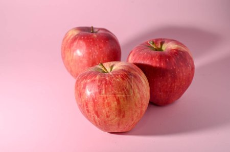 Téléchargez les photos : Trois pommes rouges sur fond rose 2 - en image libre de droit