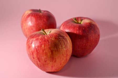 Téléchargez les photos : Trois pommes rouges sur fond rose 6 - en image libre de droit