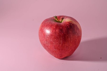 Téléchargez les photos : Pomme rouge sur fond rose - en image libre de droit