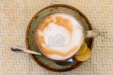 cappuccino chaud avec mousse sur une table dans un café
