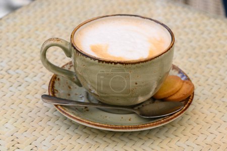 Cup of cappuccino on a table in a cafe. Beautiful foam, white ceramic cup, copy space. 4