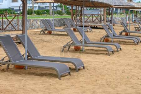 Strandgänger mit Sonnenschirmen am Strand des Mittelmeeres 1