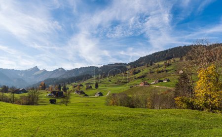 Foto de Paisaje montañoso en la región de Toggenburg con casas rurales, prados verdes y pastos, Mt. Speer en el fondo, Nesslau, Canton St. Gallen, Suiza - Imagen libre de derechos