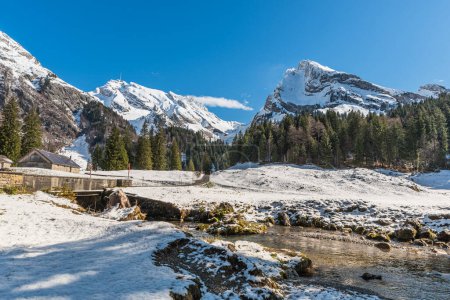 Foto de Alp con arroyo y vista de Saentis y Wildhuser Schafberg, paisaje nevado, Wildhaus-Alt St Johann, Toggenburg, Canton St. Gallen, Suiza - Imagen libre de derechos