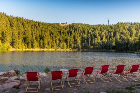Photo for Red, empty deckchairs at Mummelsee Lake with view of the Hornisgrinde, Black Forest National Park, Seebach, Baden-Wuerttemberg, Germany - Royalty Free Image