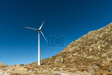 Photo for Wind turbine on rocks against blue sky on the Gotthard Pass, Canton of Ticino, Switzerland - Royalty Free Image