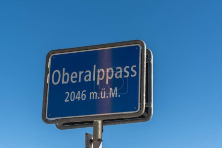 Primer plano de un cartel con el nombre de un lugar azul en la parte superior del paso Oberalp, Cantón de Graubuenden, Suiza