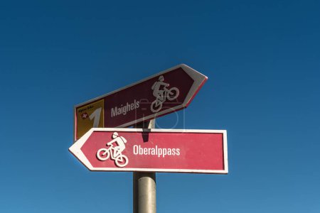 Mountain bike trail sign against blue sky, Oberalp Pass, Canton of Graubuenden, Switzerland