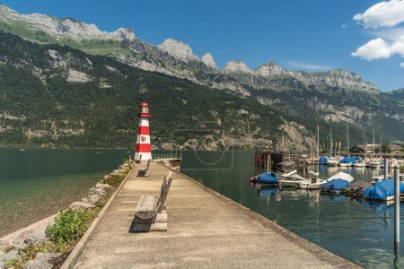 Foto de Puerto en el lago Walen (Walensee) con muelle y faro, vista a la Churfirsten, Unterterzen, Cantón de St. Gallen, Suiza - Imagen libre de derechos