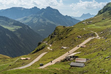 Mountain landscape with pass road and huts at Klausen Pass, a high mountain pass in the Swiss Alps, connecting Altdorf in the canton of Uri and Linthal in the canton of Glarus, Switzerland