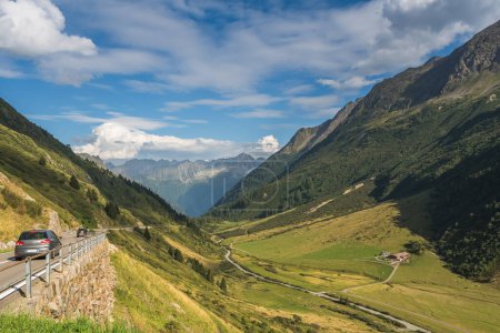 Cars drive at Susten Pass road, idyllic mountain landscape, Meien, Canton of Uri, Switzerland. Susten Pass is a mountain pass in the Swiss Alps that connects the cantons of Bern and Uri. 