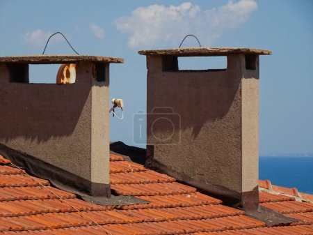 Photo for Roof top chimneys with sea at the background - Royalty Free Image
