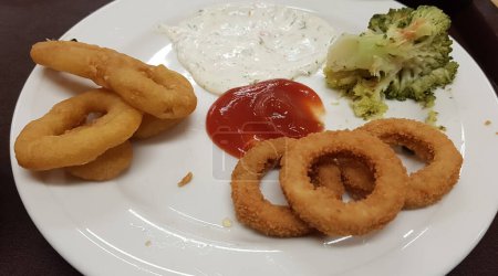 Photo for Close up image of half eaten food plate with broccoli, onion rings and calamari - Royalty Free Image