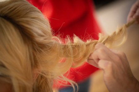 Téléchargez les photos : Processus de fabrication d'une coiffure pour une femme blonde - en image libre de droit