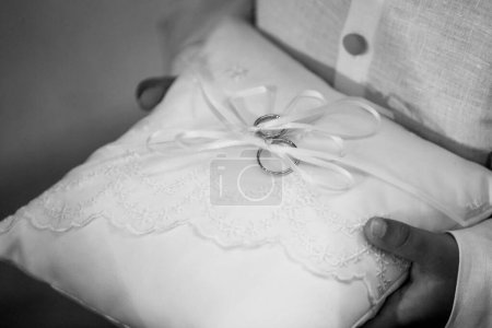 Foto de Hombre celebración de anillos de boda en la almohada blanca - Imagen libre de derechos