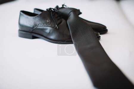Foto de Zapatos negros masculinos y corbata en el fondo blanco - Imagen libre de derechos