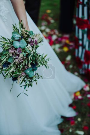 Foto de Hermosa novia en un vestido de novia con un ramo de flores - Imagen libre de derechos