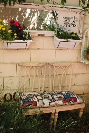 Téléchargez les photos : Chaises et fleurs dans des pots dans le jardin - en image libre de droit