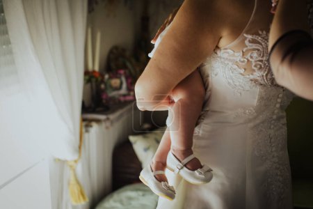Téléchargez les photos : Mariée en robe de mariée tenant bébé - en image libre de droit