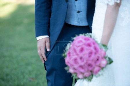 Photo for Bride and groom together, bride holding bouquet of pink flowers - Royalty Free Image