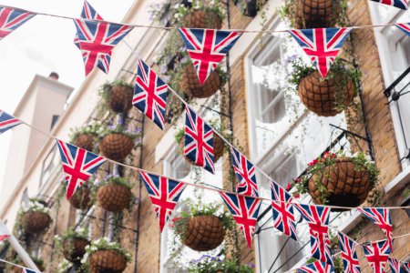 Unión Británica Jack bandera triangular colgando en preparación para una fiesta callejera. Decoraciones festivas de Union Jack bunting. Enfoque selectivo.