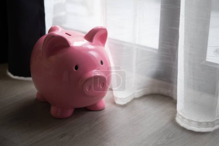 Foto de A pink piggy bank, next to it is a place for an inscription. Savings, collect money. - Imagen libre de derechos
