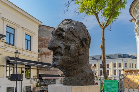 Foto de Bucarest. Rumania. Estatua del famoso actor rumano Gheorghe Dinica frente a una iglesia ortodoxa en el centro antiguo de la ciudad o Lipscani. - Imagen libre de derechos