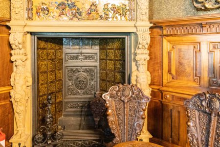 Téléchargez les photos : SINAIE, ROUMANIE - AOÛT 2022 : Intérieur du château de Peles en Roumanie. Une chambre au design classique et aux multiples détails en bois. - en image libre de droit