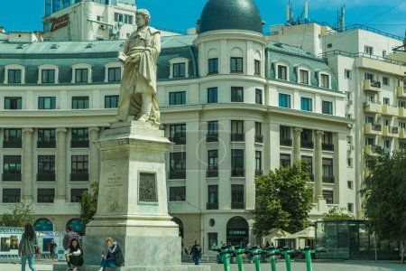 Foto de Bucarest, Rumania. Una estatua de George Lazar, un pionero de la enseñanza en Rumania y fundador de la primera escuela de idiomas, se encuentra frente al BCR Bank Palace por la universidad. - Imagen libre de derechos