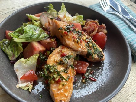 Photo for Salmon fillet fish with chimi churi with tomato beetroot salad on plate - Royalty Free Image