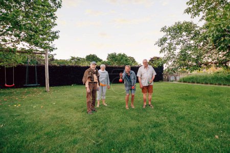 Foto de Grupo de personas mayores amigos jugando petanca en el parque - Imagen libre de derechos