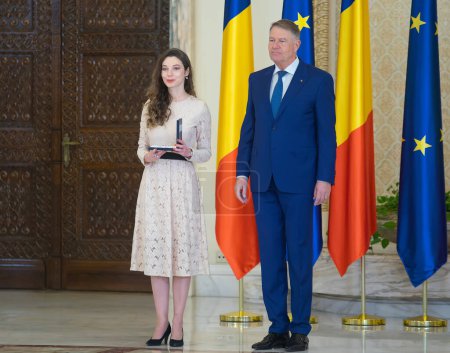Téléchargez les photos : Bucharest, Romania - January 13, 2023: Axia Ioana Cora Marinescu, pianist, is decorated by the President of Romania Klaus Iohannis on the occasion of the National Culture Day. - en image libre de droit