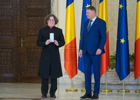 Téléchargez les photos : Bucharest, Romania - January 13, 2023: Balazs Attila receives a decoration for "Csiky Gergely" Hungarian State Theatre in Timisoara from the President of Romania Klaus Iohannis on National Culture Day - en image libre de droit