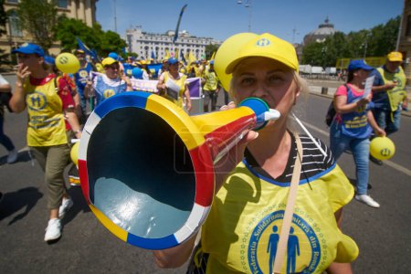 Téléchargez les photos : Bucarest, Roumanie. 8 juin 2023 : Une femme sonne à la trompette lors de la manifestation des travailleurs de la santé au centre-ville de Bucarest. Jusqu'à quatre mille travailleurs de la santé syndicaliste de la Fédération roumaine de solidarité sanitaire protestent en marche sur la route entre la hea - en image libre de droit