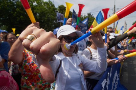 Téléchargez les photos : Bucarest, Roumanie. 9 juin 2023 : Une femme sonnant de la trompette baisse le pouce lors de la manifestation des enseignants, à Bucarest. Près de 12.000 employés du système éducatif, principalement des enseignants, protestent - en image libre de droit