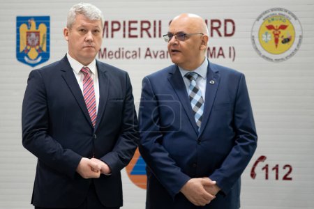 Photo for Bucharest, Romania. 5th July, 2023: Catalin Predoiu (L) speaks to Raed Arafat (R) during the presentation of 15 of the 25 advanced medical stations and four radio support vehicles assigned to IGSU - Royalty Free Image