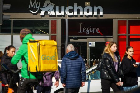 Photo for Bucharest, Romania - October 18, 2023: People walk past a store of the French multinational retailer, Auchan. - Royalty Free Image