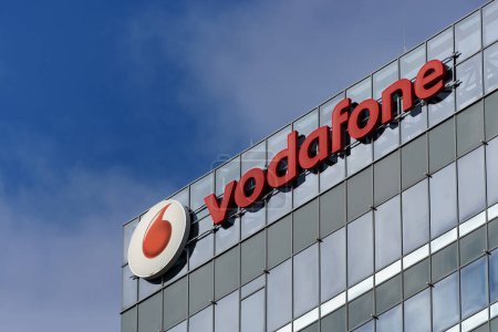 Foto de Bucarest, Rumania - 19 de febrero de 2024: Un logotipo de Vodafone, compañía británica de telecomunicaciones, se ve en la parte superior del edificio Globalworth Tower, en Bucarest. Esta imagen es solo para uso editorial. - Imagen libre de derechos