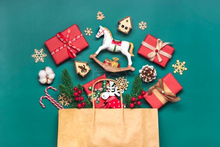 Coffrets cadeaux rouges emballés à la main décorés avec des rubans, des flocons de neige et des chiffres, décorations de Noël et décoration en sac sur table verte Concept de calendrier de l'Avent de Noël Vue de dessus Pose plate Carte de vacances