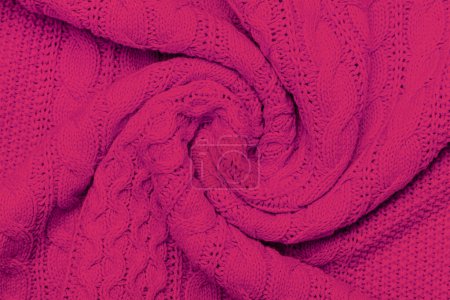 La texture du pull tricoté chaud. Magnifique motif répétitif tricoté à la main. Démonstration couleur Pantone de l'année 2023 viva magenta.