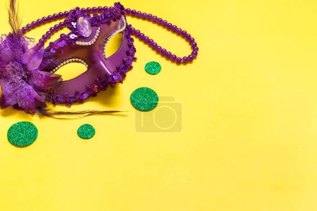 Mardi gras lettering. Congratulation card with violet mask on yellow background Top view 2023 Mardi Gras Parade Schedule Mockup Copy space.