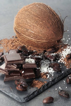 Photo for Broken dark chocolate and cocoa beans and coconut on the table - Royalty Free Image
