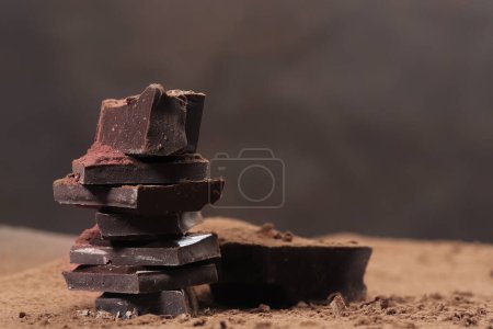 Photo for Broken dark chocolate and chocolate flakes on a wooden table - Royalty Free Image