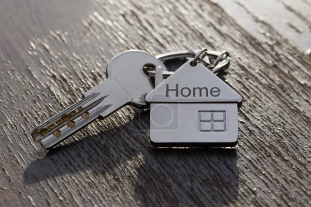 Téléchargez les photos : Symbole de la maison avec des clés argentées sur fond abstrait. Concept immobilier - en image libre de droit