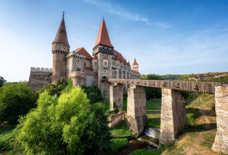 Sommerblick mit Schloss Corvin mit Brücke über einen kleinen Fluss an einem sonnigen Tag in Rumänien